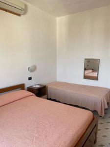 a room with two beds and a mirror on the wall at Casa La Perla in Ischia