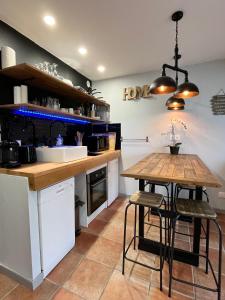 a kitchen with a wooden counter and a table at Studio moderne au pied des pistes, emplacement idéal, central et calme in Le Dévoluy +8 photos