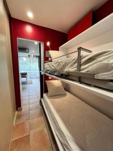 2 Etagenbetten in einem Zimmer mit roten Wänden in der Unterkunft Studio moderne au pied des pistes, emplacement idéal, central et calme in Le Dévoluy
