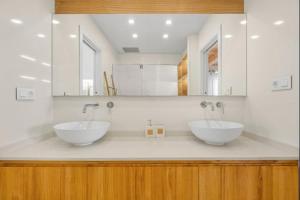two sinks in a bathroom with two mirrors at Luxury on the beachfront in El Campello +8 photos