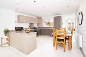 a kitchen and dining room with a table and chairs at Kiln Side by Truestays - 3 Bedroom House in Etruria