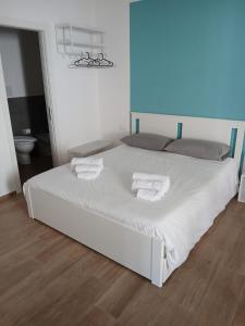 a bedroom with a white bed with towels on it at Esse & Emme in Palermo