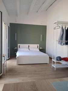 a bedroom with a white bed and a green wall at Esse & Emme in Palermo