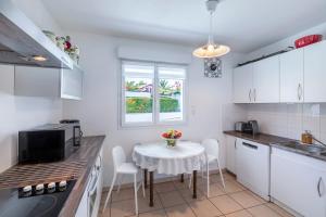 a kitchen with a table and a small table with chairs at Appartement Iris - Welkeys in Ciboure