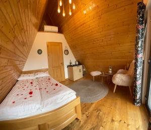 a bedroom with a bed in a wooden cabin at A FRAME 1 TRANSALPINA in Petreşti +112 photos