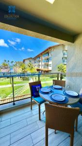 a patio with a table and chairs on a balcony at La Fleur Collection Vacation Homes - Residence & Resort in Porto De Galinhas