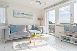 a living room with a couch and a tv at Meerkieker in Albertsdorf