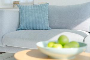 a bowl of fruit on a table next to a couch at Meerkieker in Albertsdorf