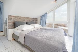 a bedroom with a bed and a large window at Meerkieker in Albertsdorf