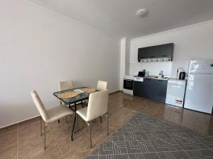 une salle à manger avec une table et des chaises et une cuisine dans l'établissement Apartment in the complex Olymp, à Sveti Vlas