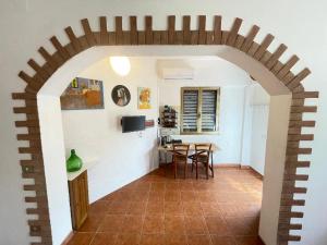 a kitchen and dining room with an archway in a house at Stefania Guest House in Giba