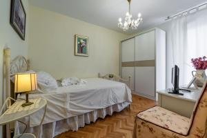 Un dormitorio con una cama, un escritorio y un televisor. en Apartments Zoran, en Split