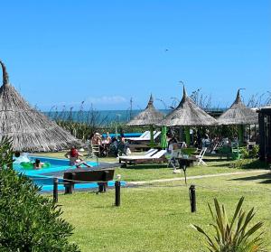 a group of people playing in a pool with umbrellas at Sotavento Apart Hotel in La Paloma