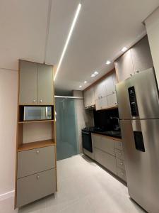 a kitchen with a stainless steel refrigerator and cabinets at Apto 3 dormitórios com suíte em São José Dos Campos SP in São José dos Campos