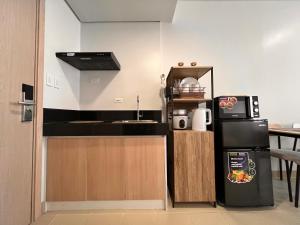 a small kitchen with a sink and a refrigerator at The Spot in Marilao