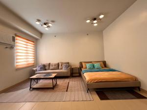 a bedroom with a bed and a couch at The Spot in Marilao