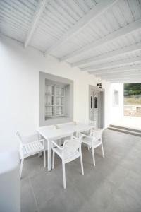 a white dining room with a white table and chairs at Olive garden house in Kalymnos