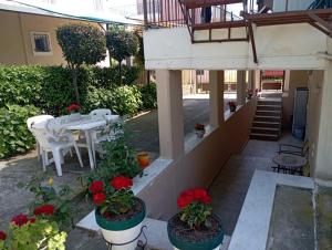 a patio with a table and flowers in pots at John's & Maria's house in Agiokampos
