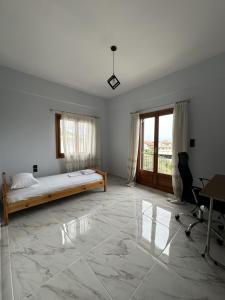 a bedroom with a bed and a desk and a window at Athenas' Modern Oasis in Kamena Vourla