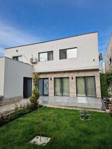 a modern house with a green yard at Villa Niko in Mamaia Sat/Năvodari