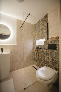 a bathroom with a toilet and a glass shower at Acasa la Pojorata in Pojorâta