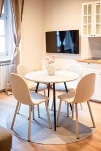 a table and chairs in a living room with a tv at Kaptol 2 in Zagreb
