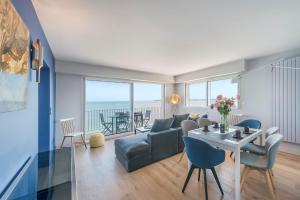 a living room with a couch and a table at Vue sur mer La Baule Victoria in La Baule