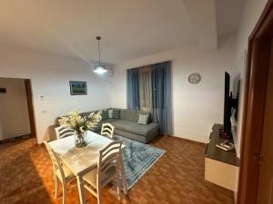 a living room with a table and a couch at Tirana Rad Apartment in Patza-Kuqani