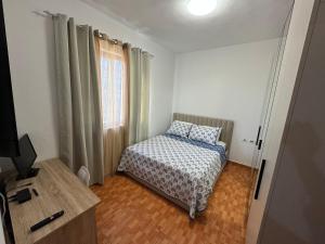 a small bedroom with a bed and a window at Tirana Rad Apartment in Patza-Kuqani