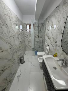 a bathroom with a sink and two toilets at Tirana Rad Apartment in Patza-Kuqani +7 photos