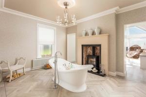 a bathroom with a white tub and a fireplace at No36 South Beach - Donnini Apartments in Troon
