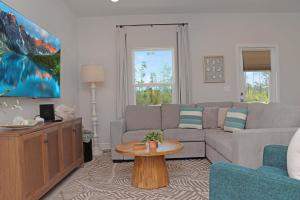 a living room with a couch and a table at Salty Beaches by Pristine Property Vacation Rentals in Saint Joe Beach