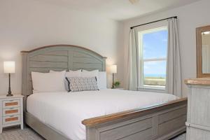 a bedroom with a large white bed and a window at Salty Beaches by Pristine Property Vacation Rentals in Saint Joe Beach +58 photos