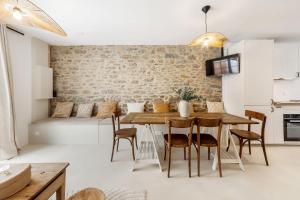 a kitchen and dining room with a wooden table and chairs at La Pause - Maison de charme avec terrasse - 2 chambres in Dinard