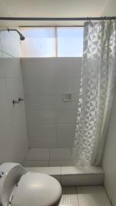 Un baño blanco con ducha y WC. en El Álamo, en Arequipa
