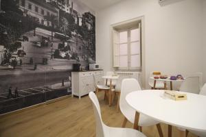 una sala da pranzo con tavoli e sedie bianche e un murale di Leoni di Sicilia a Palermo