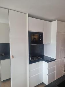 una cucina con mobili bianchi e un forno a microonde di Cap d'agde Village naturiste Studio Shabby Chic a Cap d'Agde