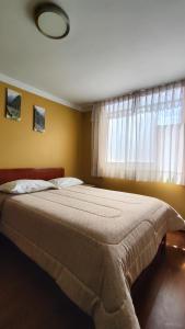 Un dormitorio con una cama grande con ventana. en El Álamo, en Arequipa
