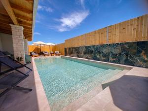 a swimming pool with some chairs and a table at Luxury Villa Levanda in Ksamil