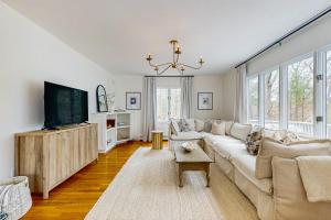 a living room with a white couch and a tv at Willow Cove in York