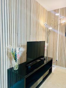 a living room with a television and a vase of flowers at Appartement avec piscine et barbecue in La Farlède