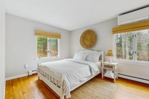 a white bedroom with a bed and two windows at Willow Cove in York