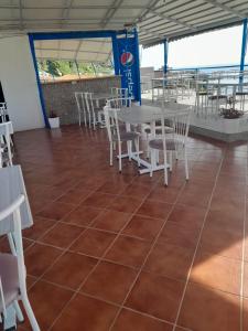 a restaurant with tables and chairs on a tiled floor at Guesthouse Mili in Piqeras