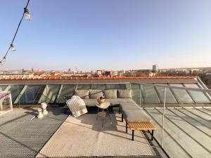 einen Balkon mit einem Sofa und einem Tisch auf dem Dach in der Unterkunft Penthouse Deluxe I Dachterrasse I Parkplatz in Dresden
