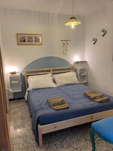 a bedroom with a blue bed with towels on it at Casa Berri in Vejer de la Frontera