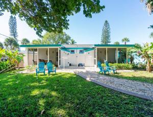 a house with three blue chairs in the yard at Turtle Cay in Englewood