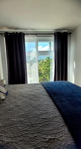 a bedroom with a bed with a large window at Take a rest nearest to Antigua Guatemala in Santa Lucía Milpas Altas