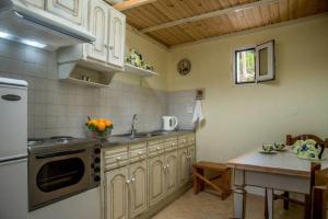 a kitchen with white cabinets and a sink and a table at Katerina's garden Apartment 2 - Tertsa Ierapetra in Térsa
