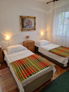 a bedroom with two beds and a picture on the wall at APP_garden_1 in Novi Vinodolski