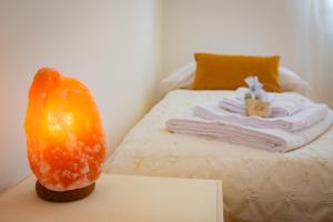 a bed with a pile of towels and an orange on a table at Liviana Apartment Venice- Spacious,Free Parking,Easy Access to Venice in Marghera
